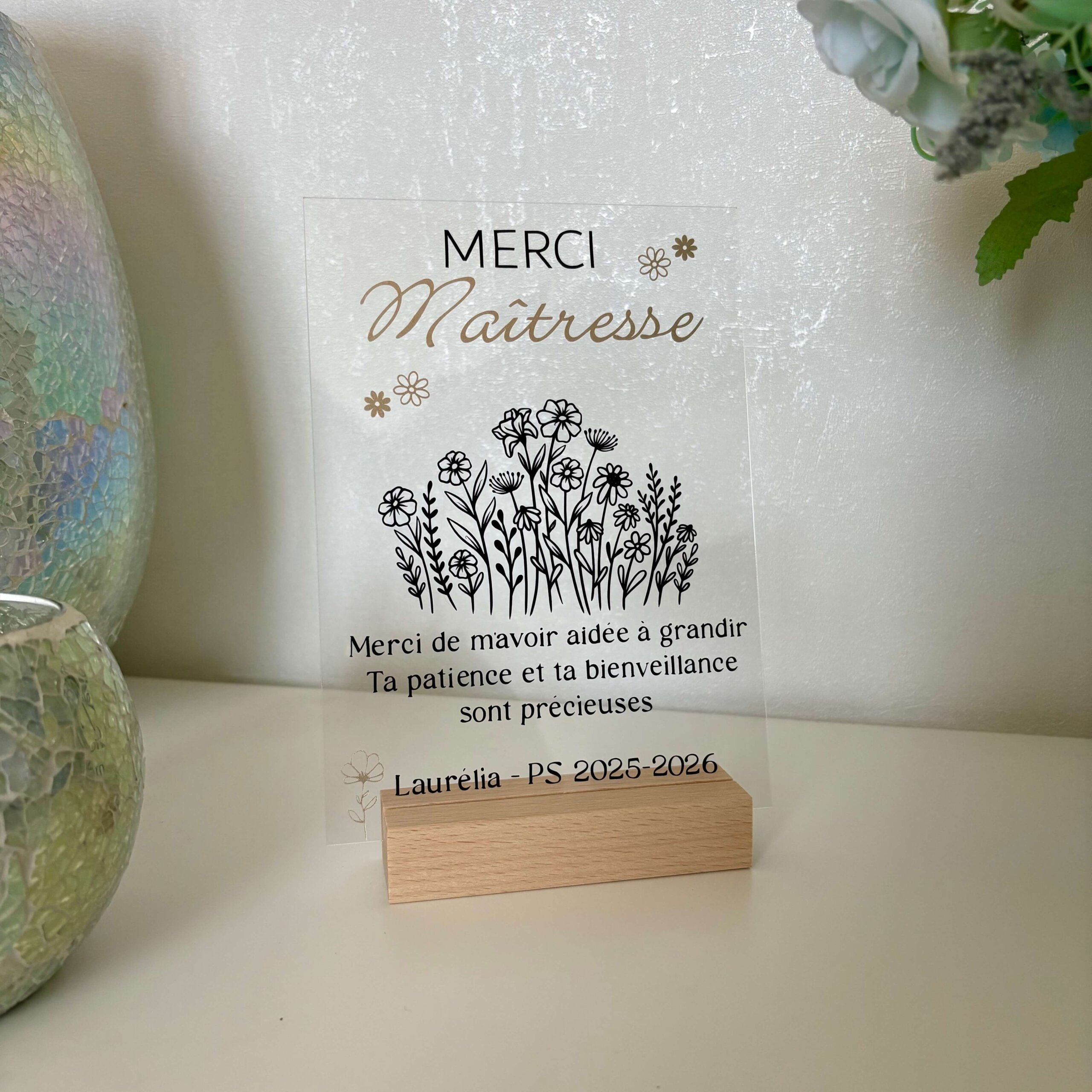 Plaque acrylique transparente Merci Maitresse avec bouquet de fleurs noir et or sur socle en bois