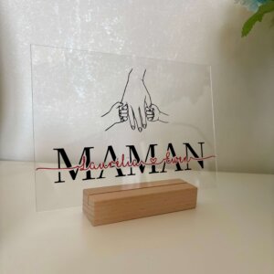 Plaque transparente en acrylique personnalisé Maman posée sur un socle en bois, écriture des prénoms avec mains maman/enfants