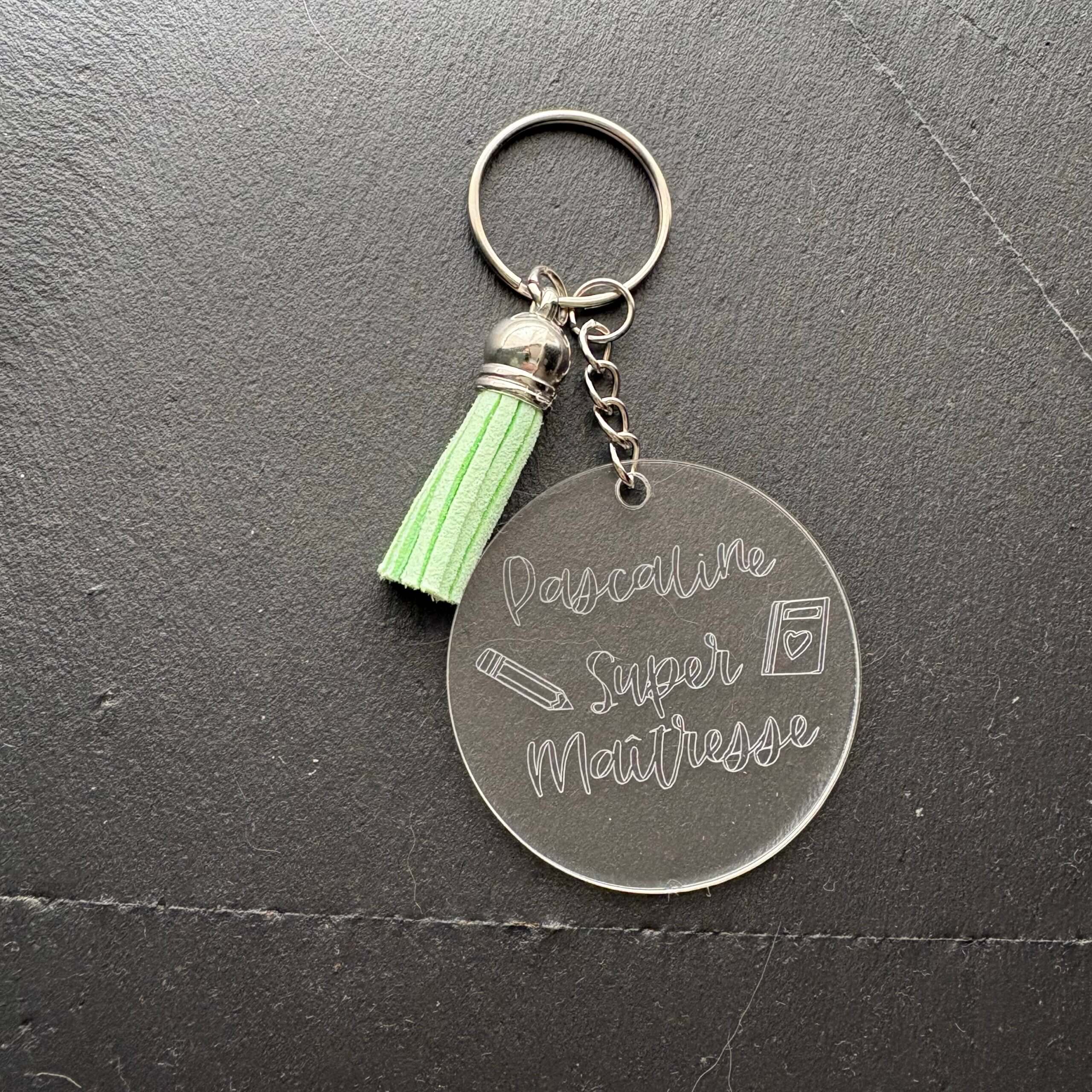 Porte-clés personnalisés en plexiglas pour maîtresse. Modèles gravés Pascaline Super Maîtresse avec pompon vert