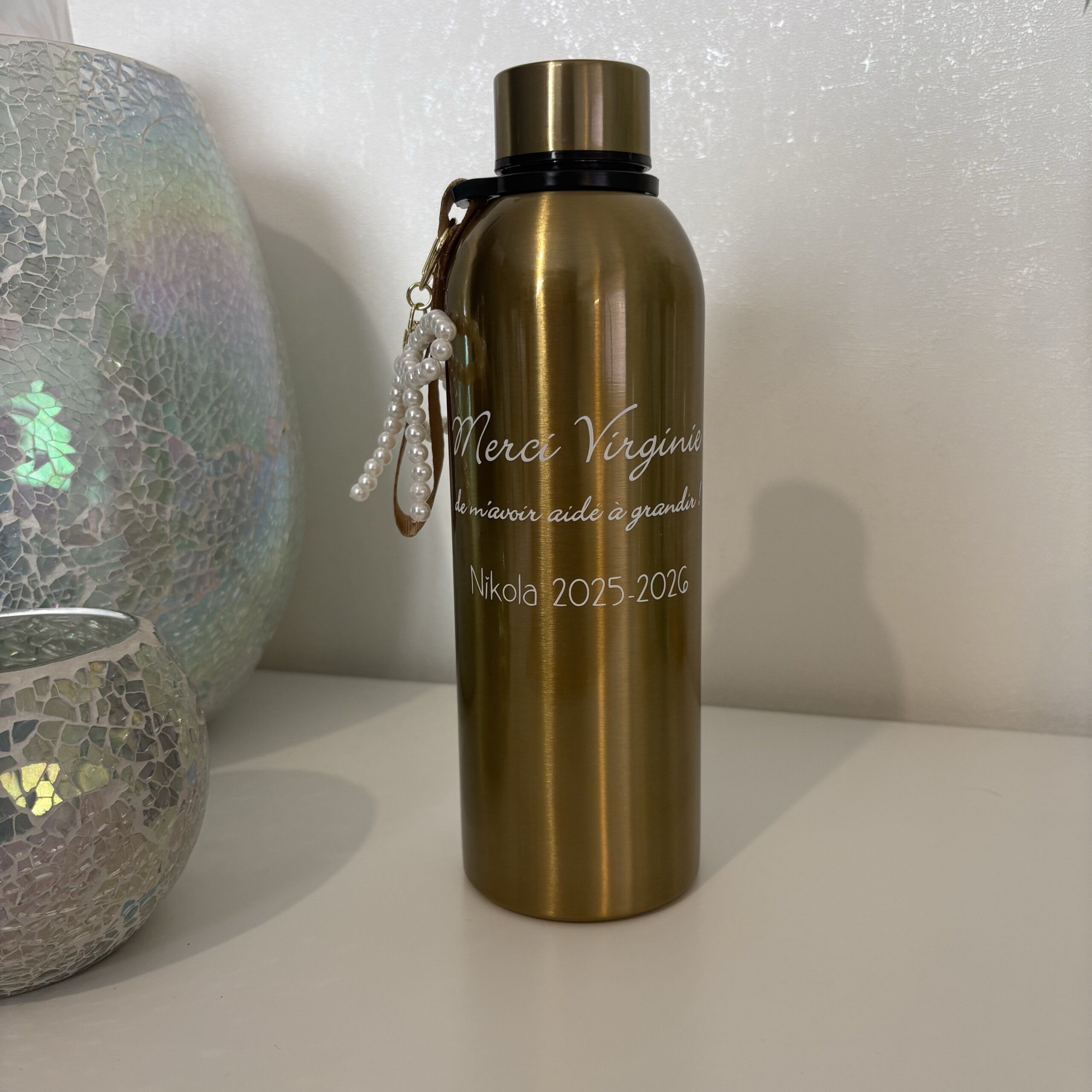Gourde isotherme personnalisée Gourde isotherme personnalisée dorée pour cadeau de fin d'année scolaire. Ecriture blanche Merci Virginie de m'avoir aidé à grandir, signée Nikola