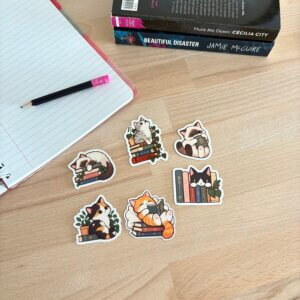 Six stickers chats lecteurs illustrés avec des livres, présentés à côté d’un carnet et de romans