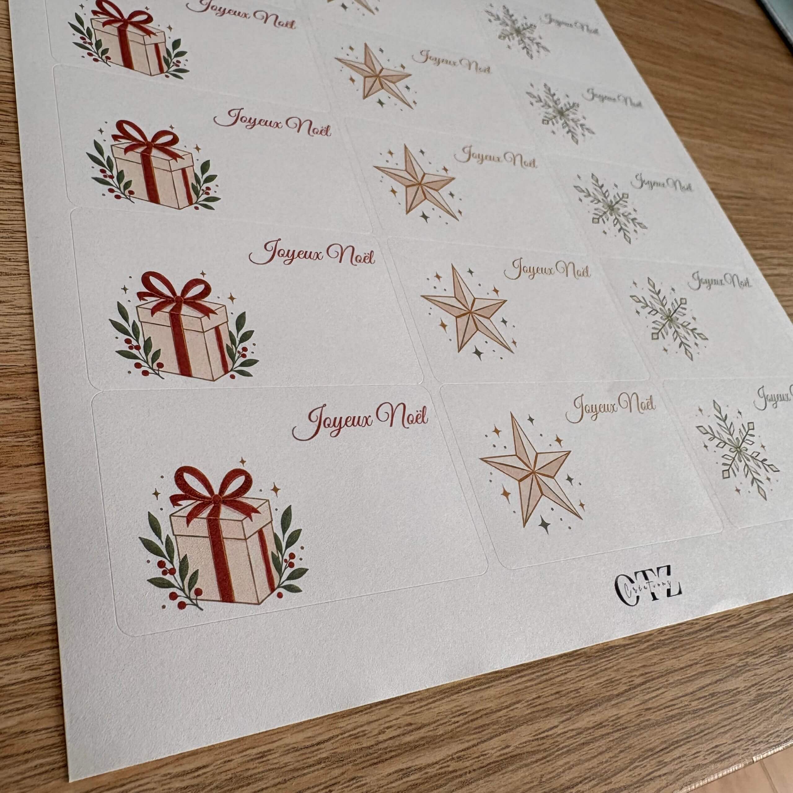 Gros plan sur les étiquettes de Noël autocollantes avec illustration de paquets cadeaux et étoiles.