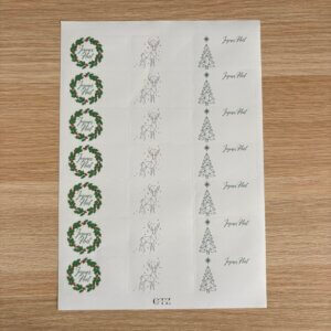 Planche complète d'étiquettes de Noël avec couronnes de houx, cerfs géométriques et sapins.