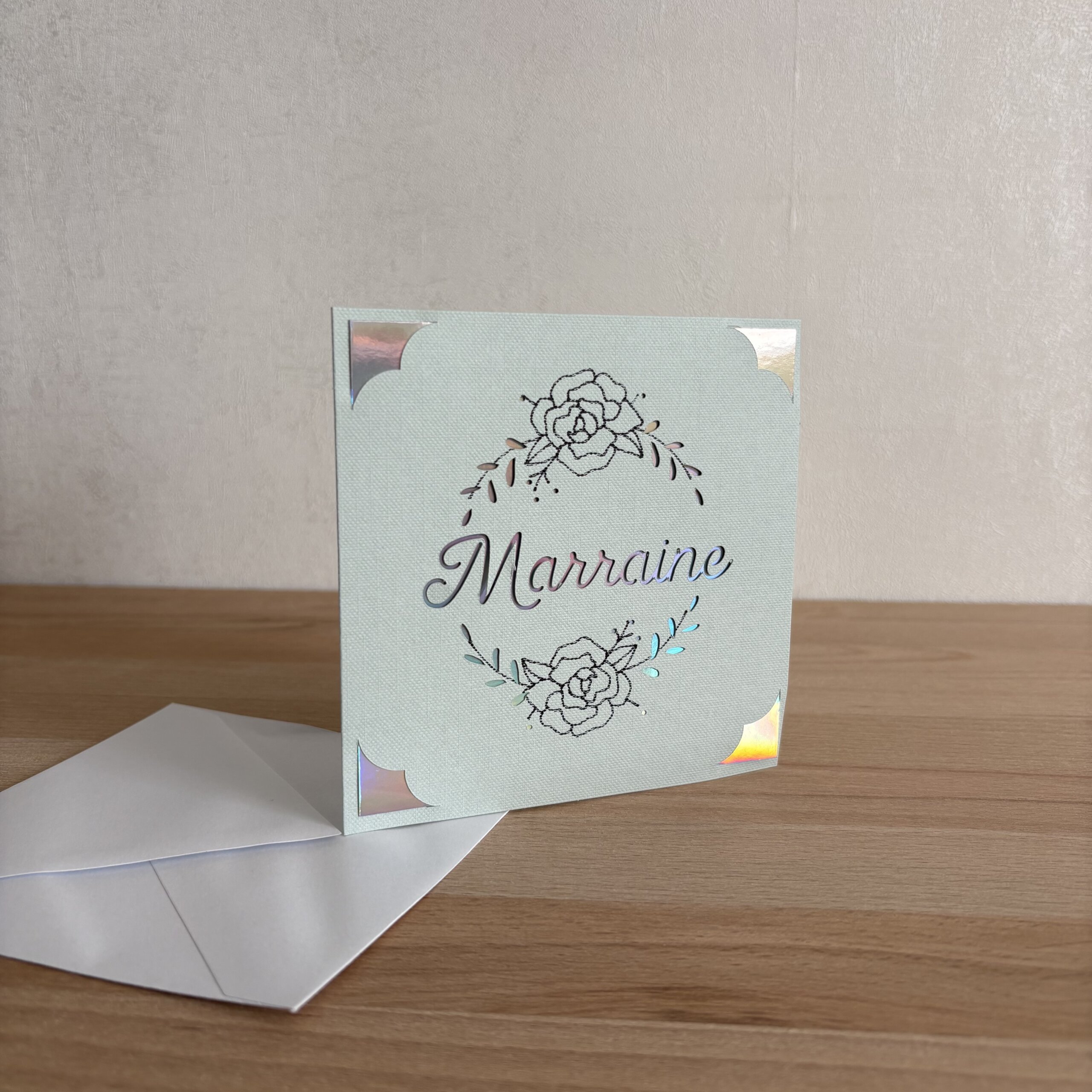 Carte Marraine faite main en papier texturé avec motif floral et détails holographiques, accompagnée de son enveloppe