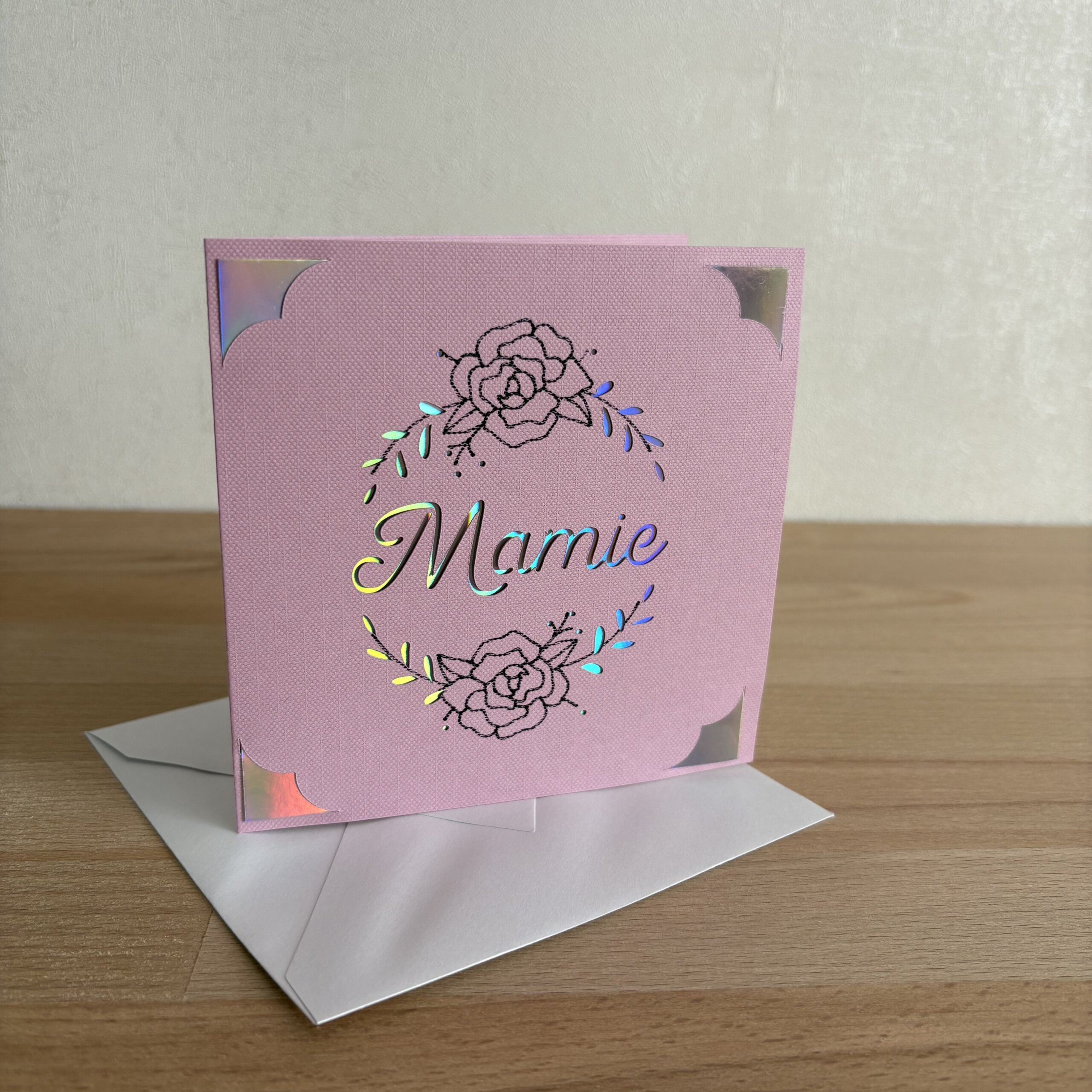 Carte Mamie violet faite main en papier texturé avec motif floral et détails holographiques, accompagnée de son enveloppe
