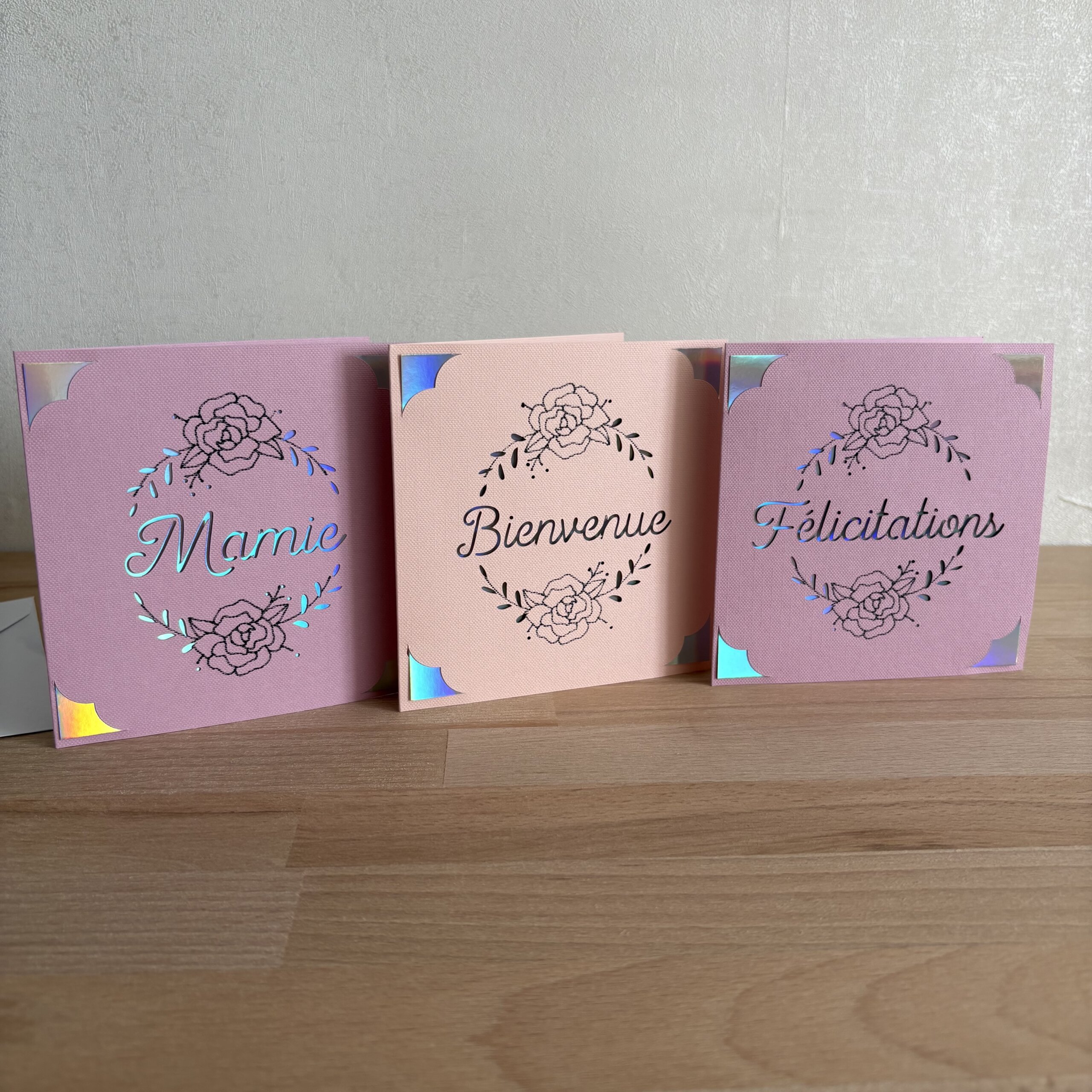 Assortiment de cartes faites main Mamie, Bienvenue et Félicitations en papier texturé rose avec motifs floraux et détails holographiques