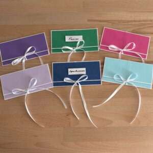 Pochettes à billets cadeau faites main en papier texturé, disponibles en plusieurs coloris avec ruban blanc