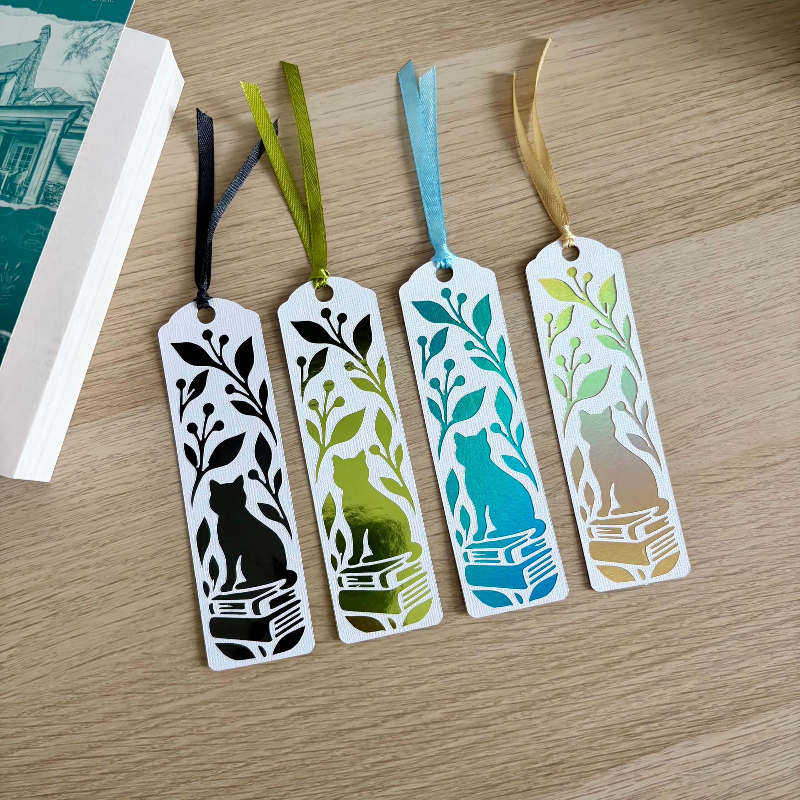Marque-pages chat sur des livres avec feuillage, en papier blanc texturé et papier miroir de différents coloris