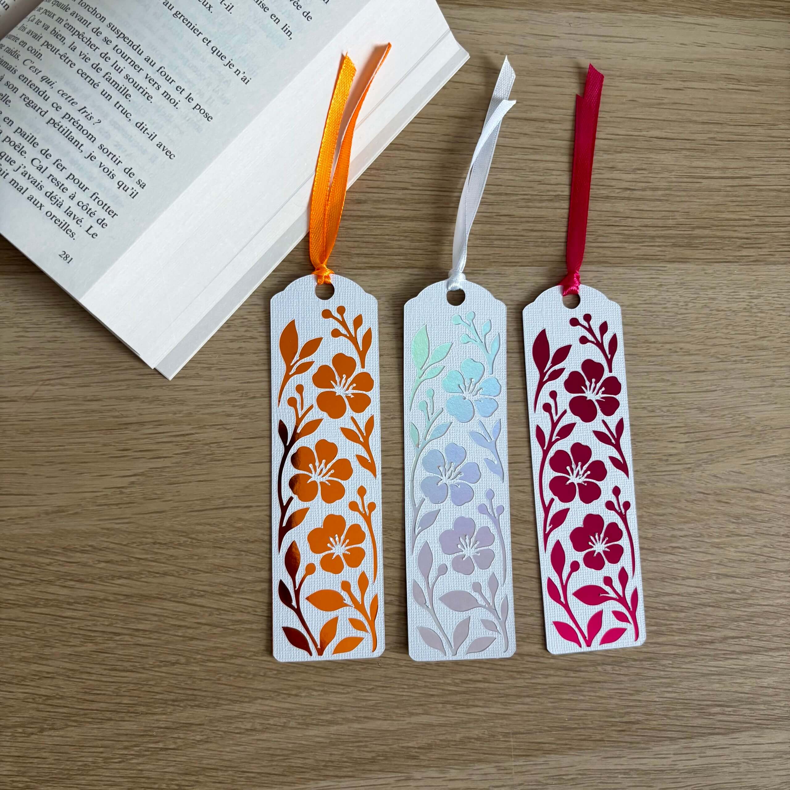 Trois marque-pages fleuris en papier blanc texturé avec papier miroir orange, holographique et rose fuchsia