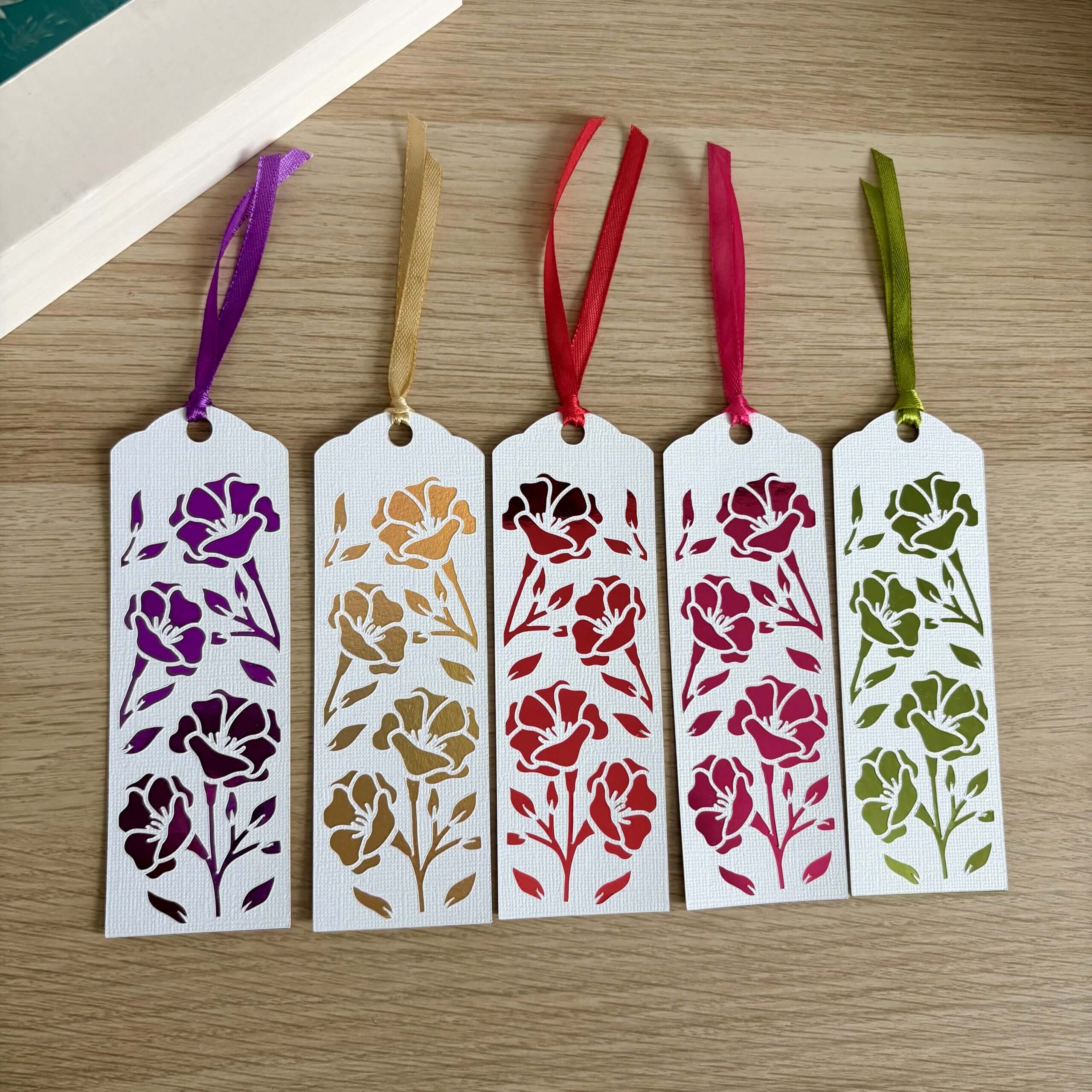 Collection de cinq marque-pages à motifs de fleurs en papier blanc texturé avec papier miroir violet, doré, rouge, rose fuchsia et vert